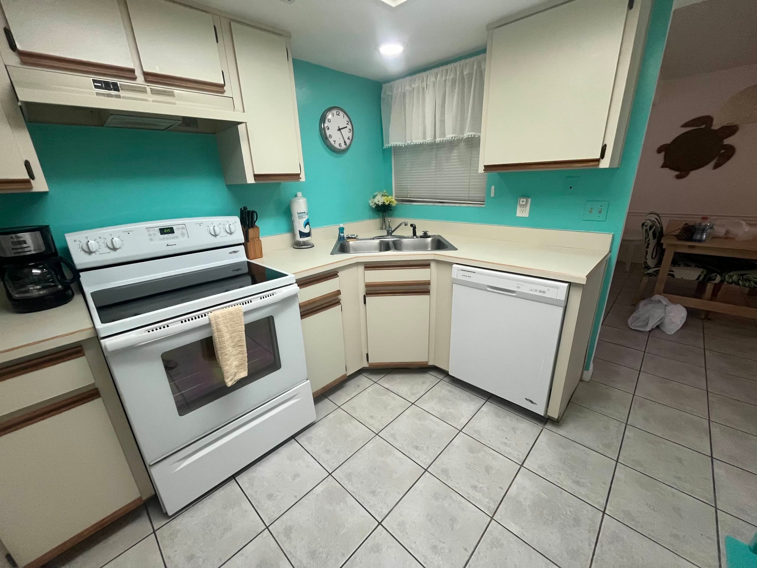 Bright kitchen with a white range, dishwasher, and wiped-down cabinets in a Volusia County rental
