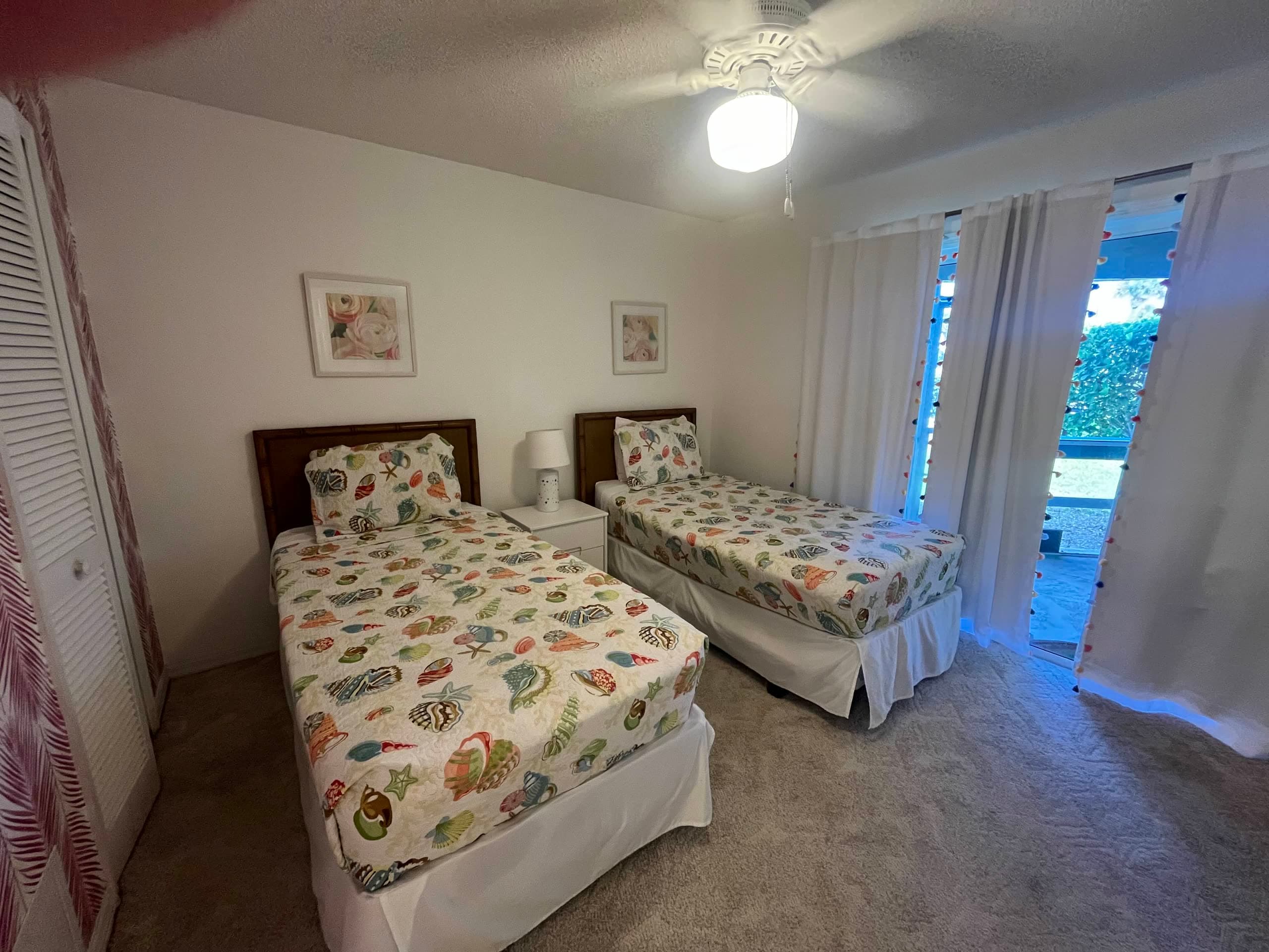 Twin bedroom with both beds made in matching seashell quilts